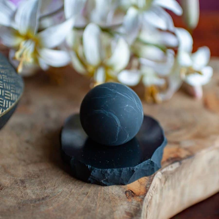 shungite orb on pedestal with flowers