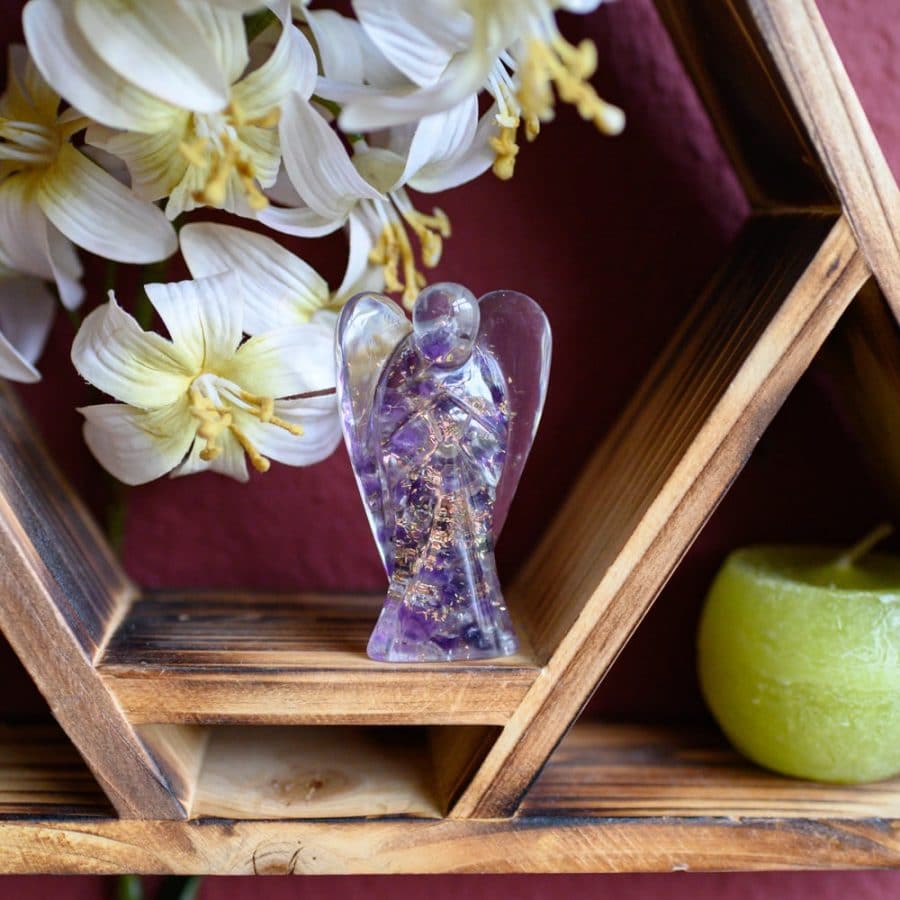 amethyst gemstone orgonite angel statue on wooden altar