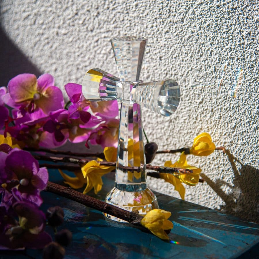 crystal cross with flowers in sunlight