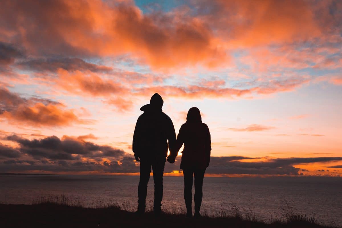 couple holding hands on the horizon