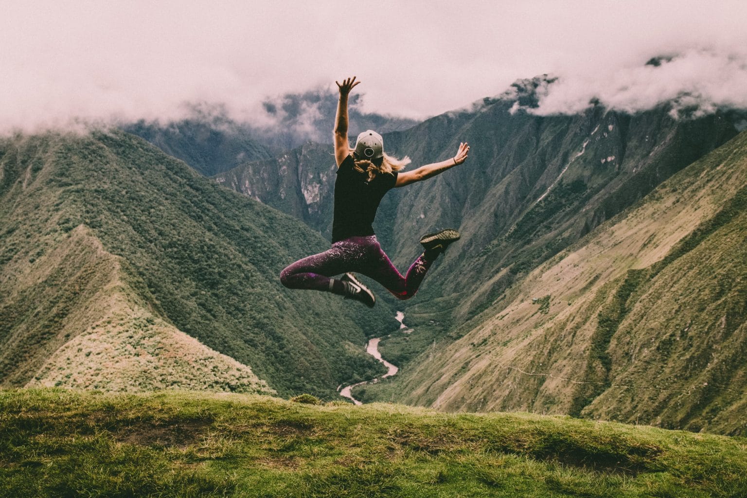 person jumping in mountains