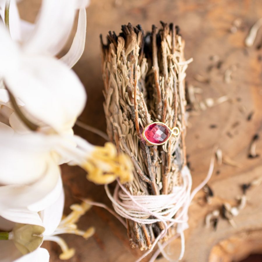 pink tourmaline pendant on white sage smudge