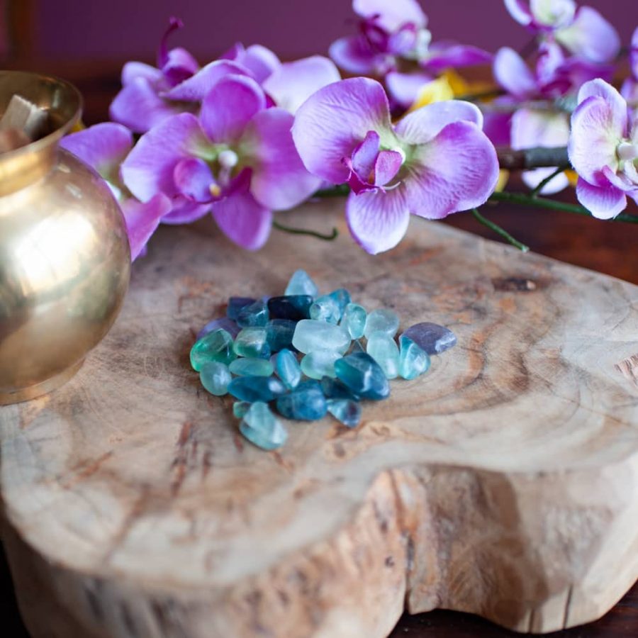 fluorite tumbled stones with brass jug and orchids
