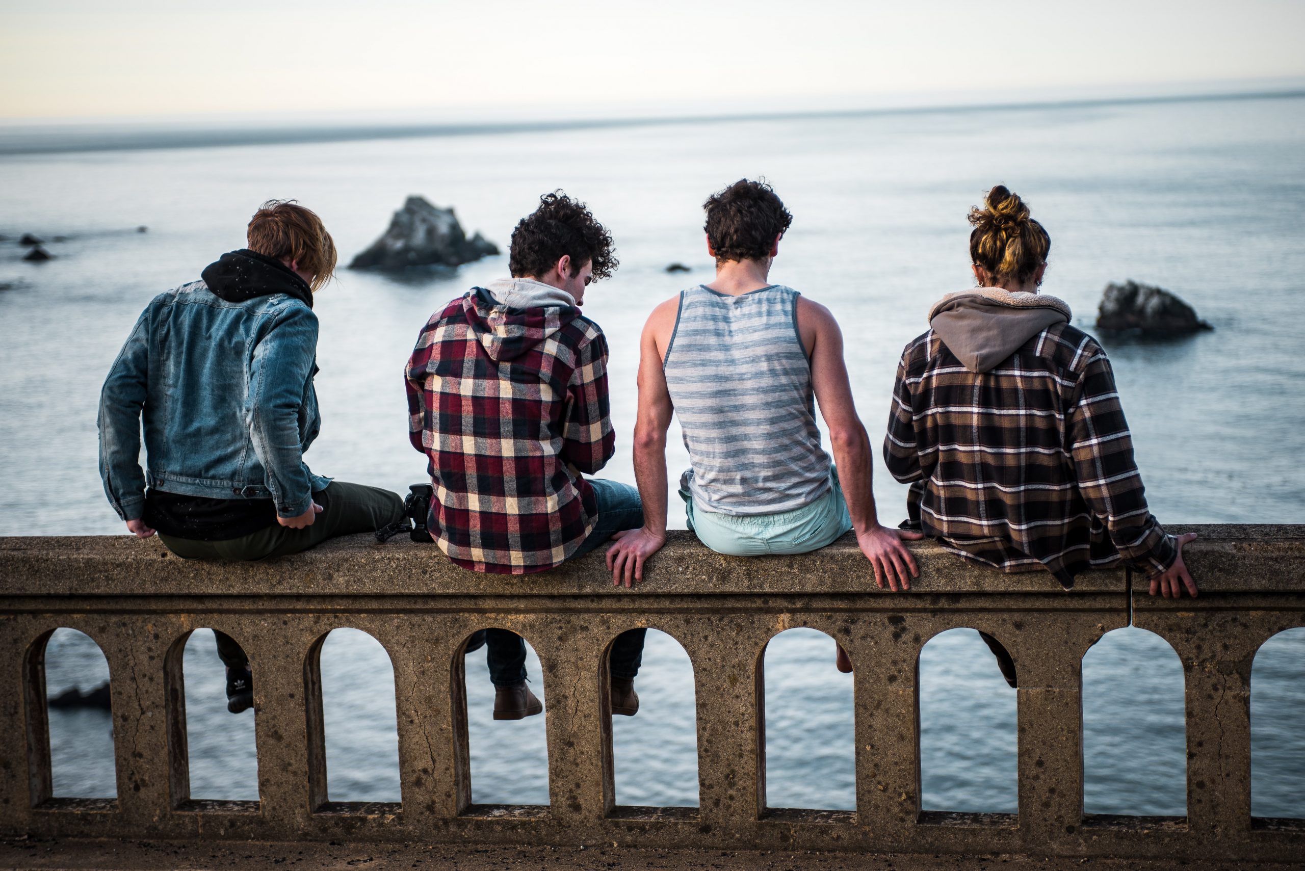 friends sitting on a bridge