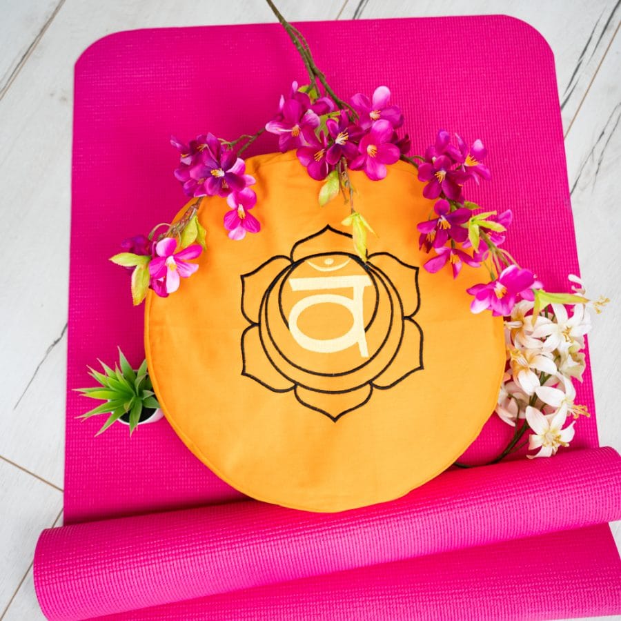 pink yoga mat with second chakra meditation cushion orange