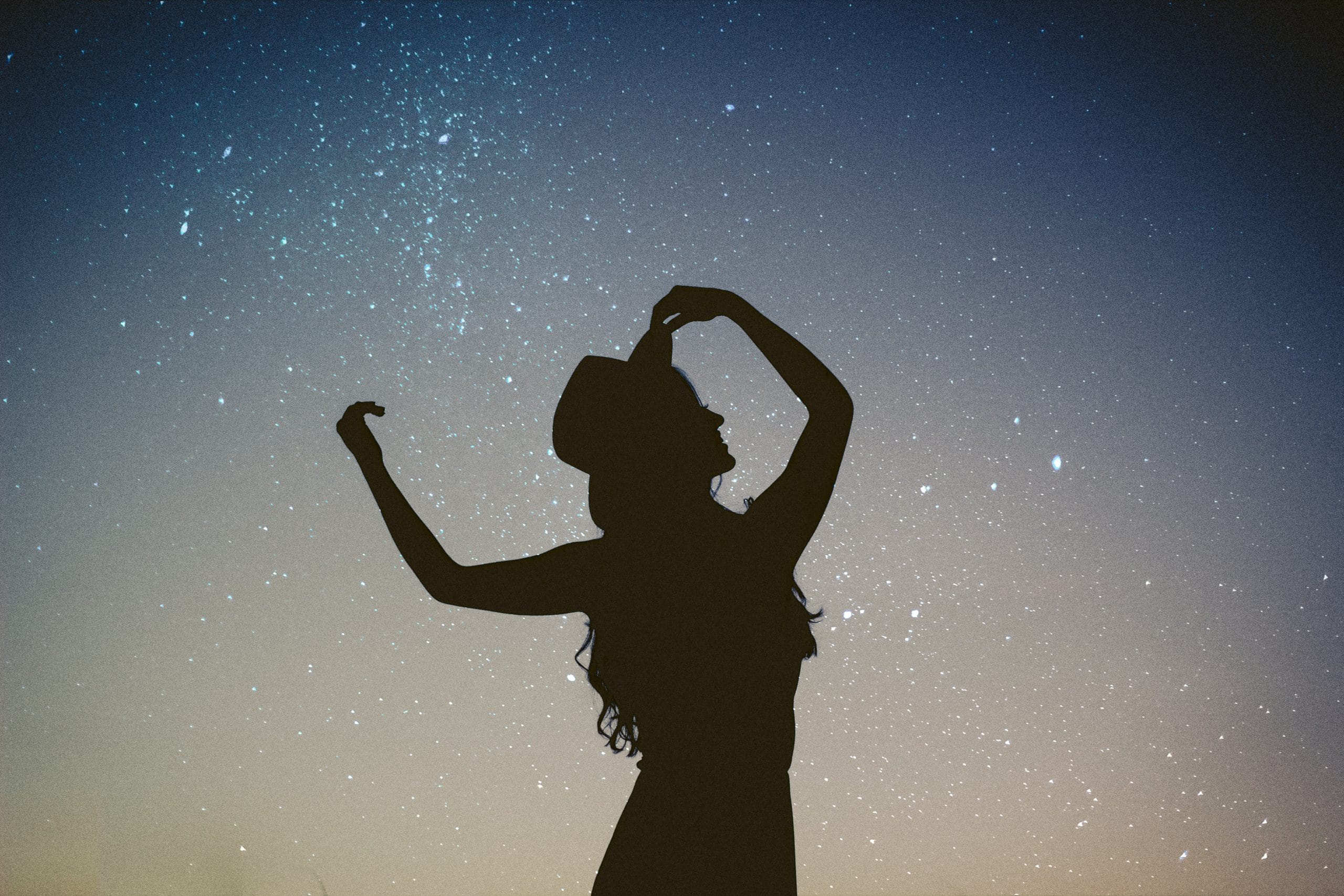 silhouette woman in front of milky way