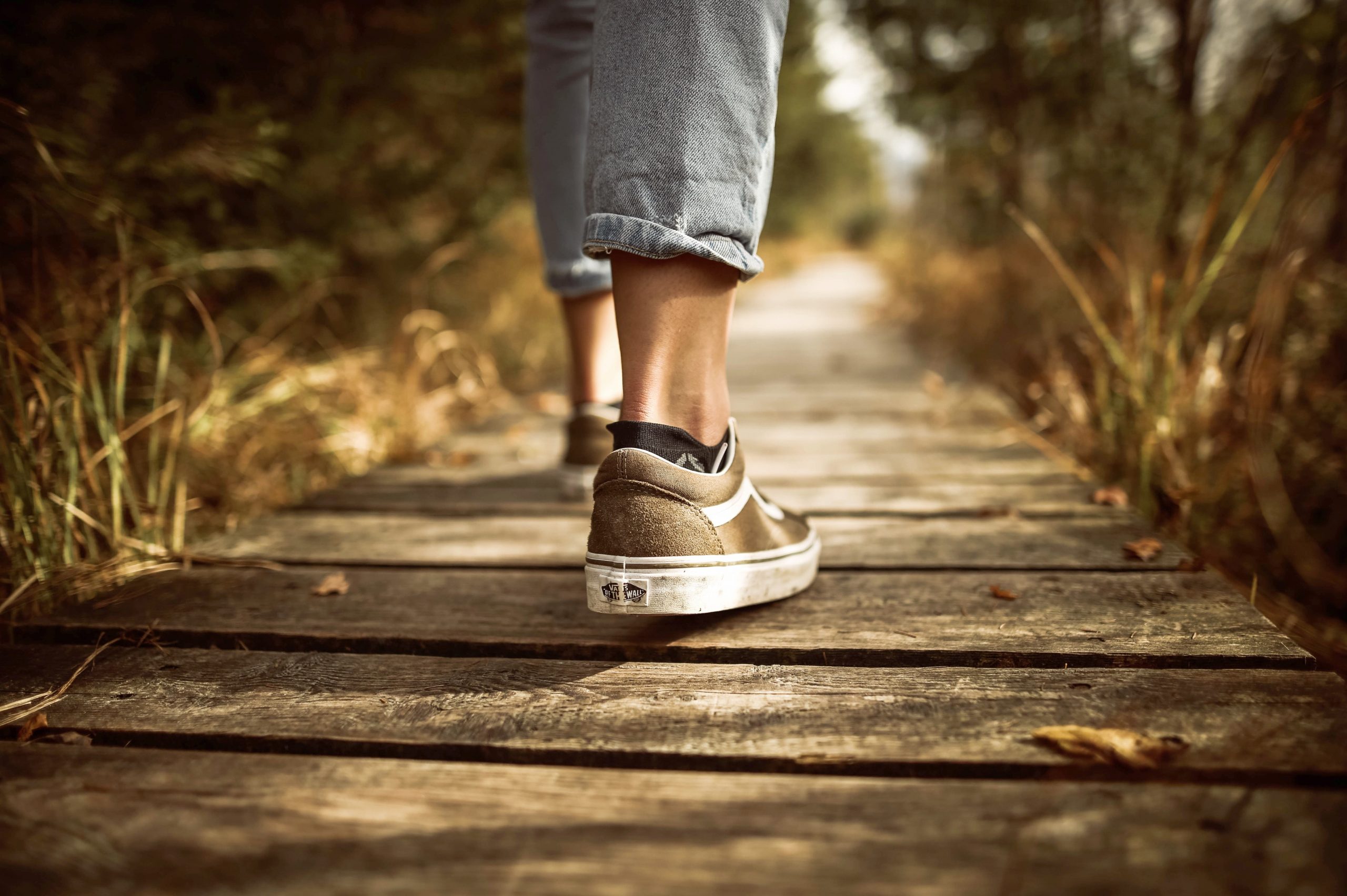 feet walking on wooden path