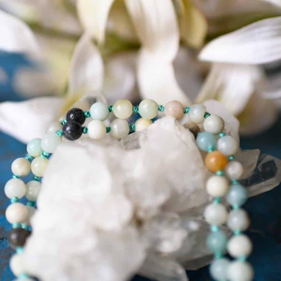 amazonite mala beads on rock crystal cluster