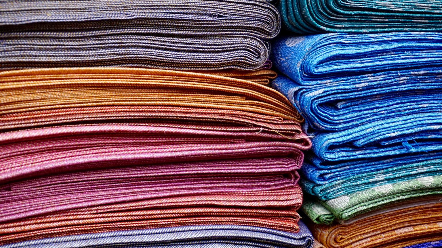 pile of folded yoga towels cotton mats colorful