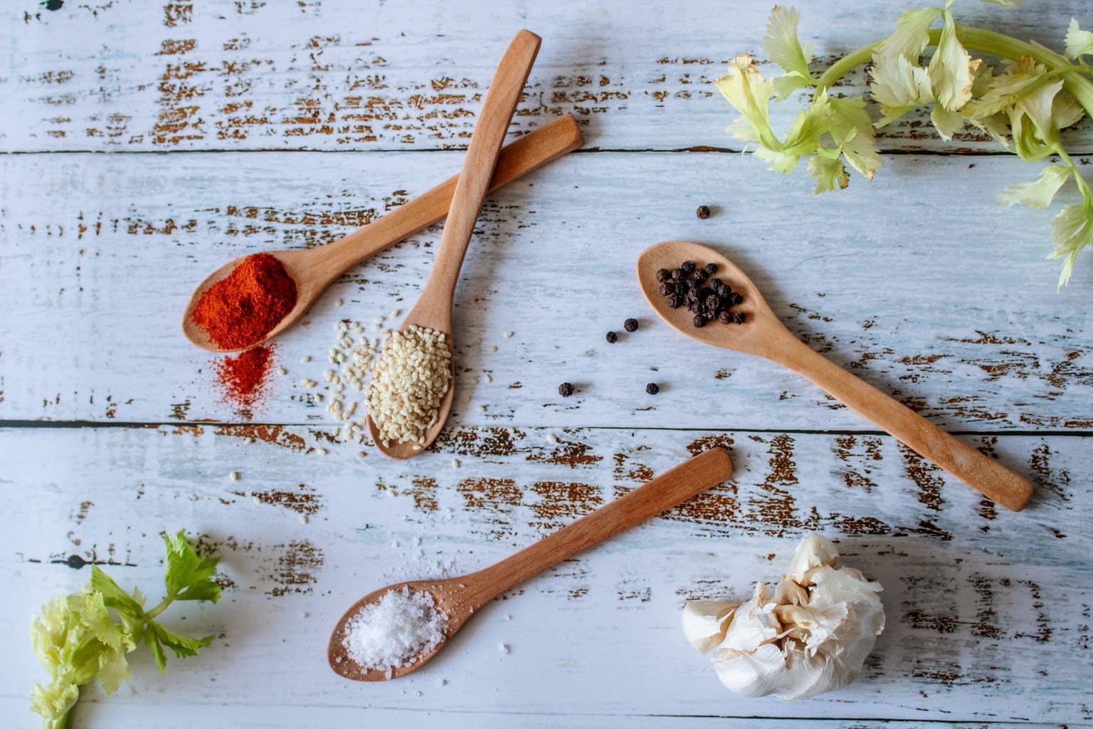 ground spices on wooden spoons