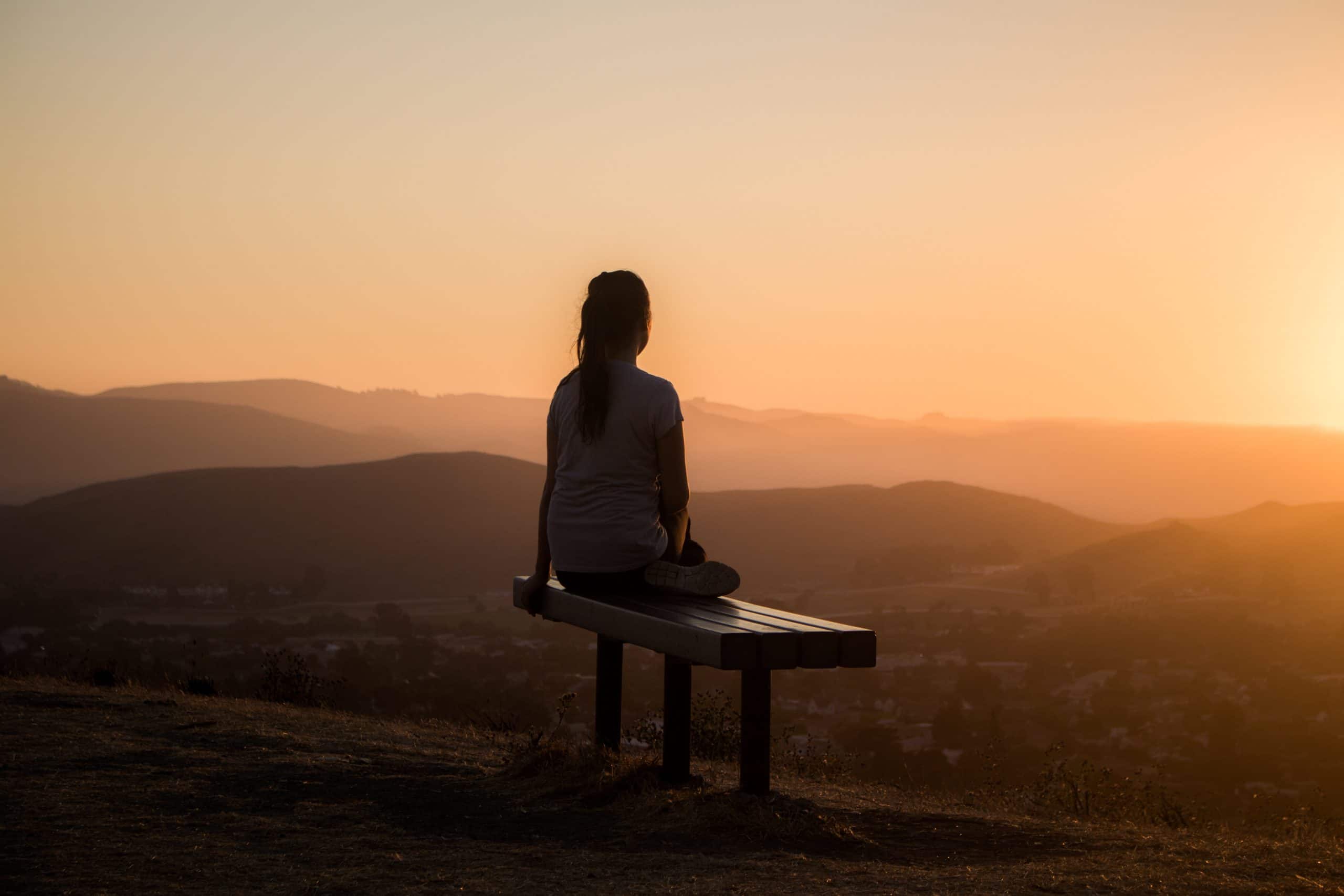 woman meditating sunset