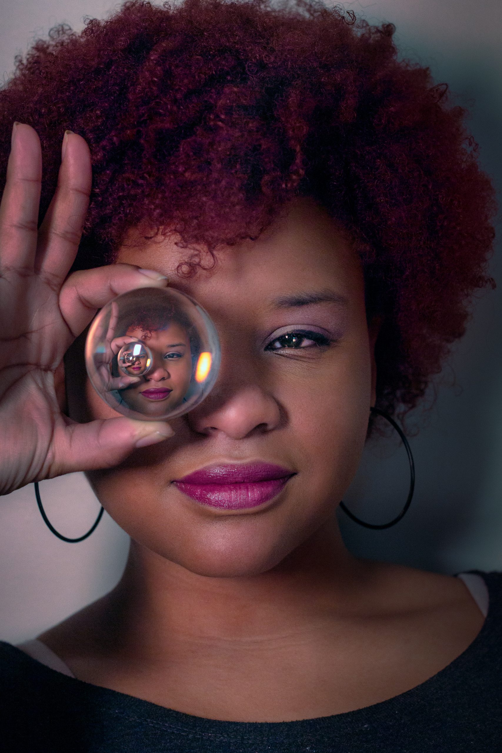 woman looking through crystal ball with reflection