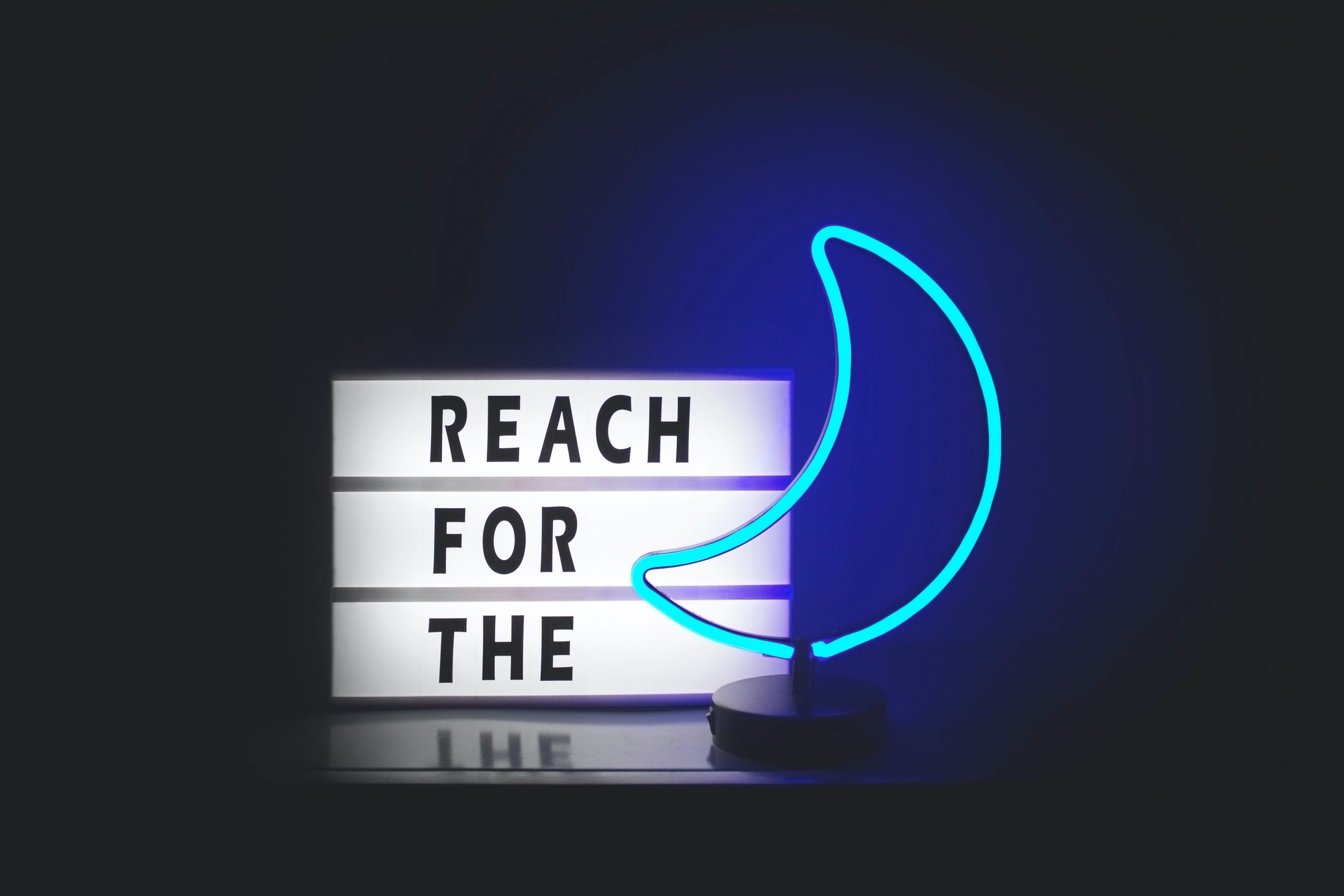 neon sign reach for the moon