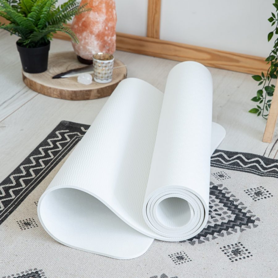 white TPE yoga mat on carpet