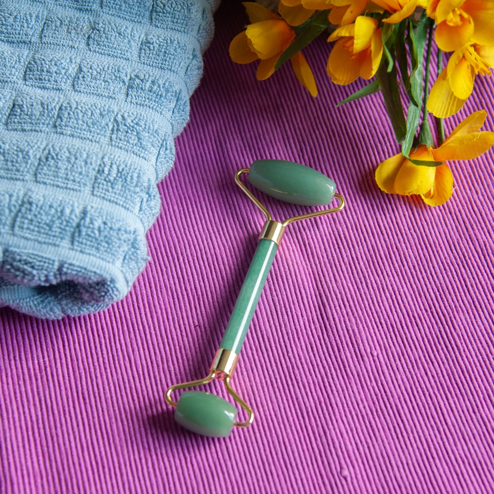 green aventurine facial massage roller blue towel flowers