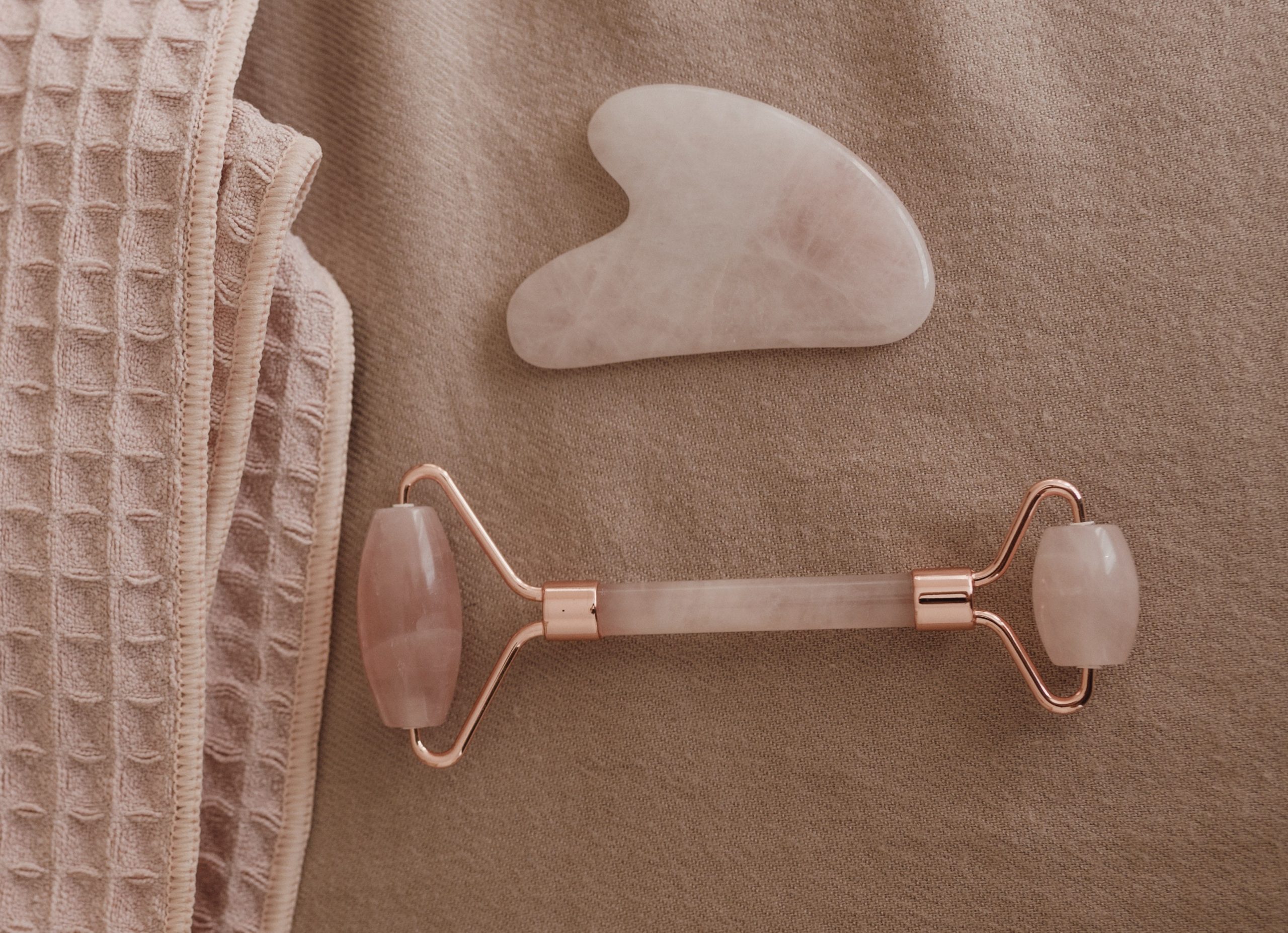 rose quartz gua sha scraper and facial roller pink towel