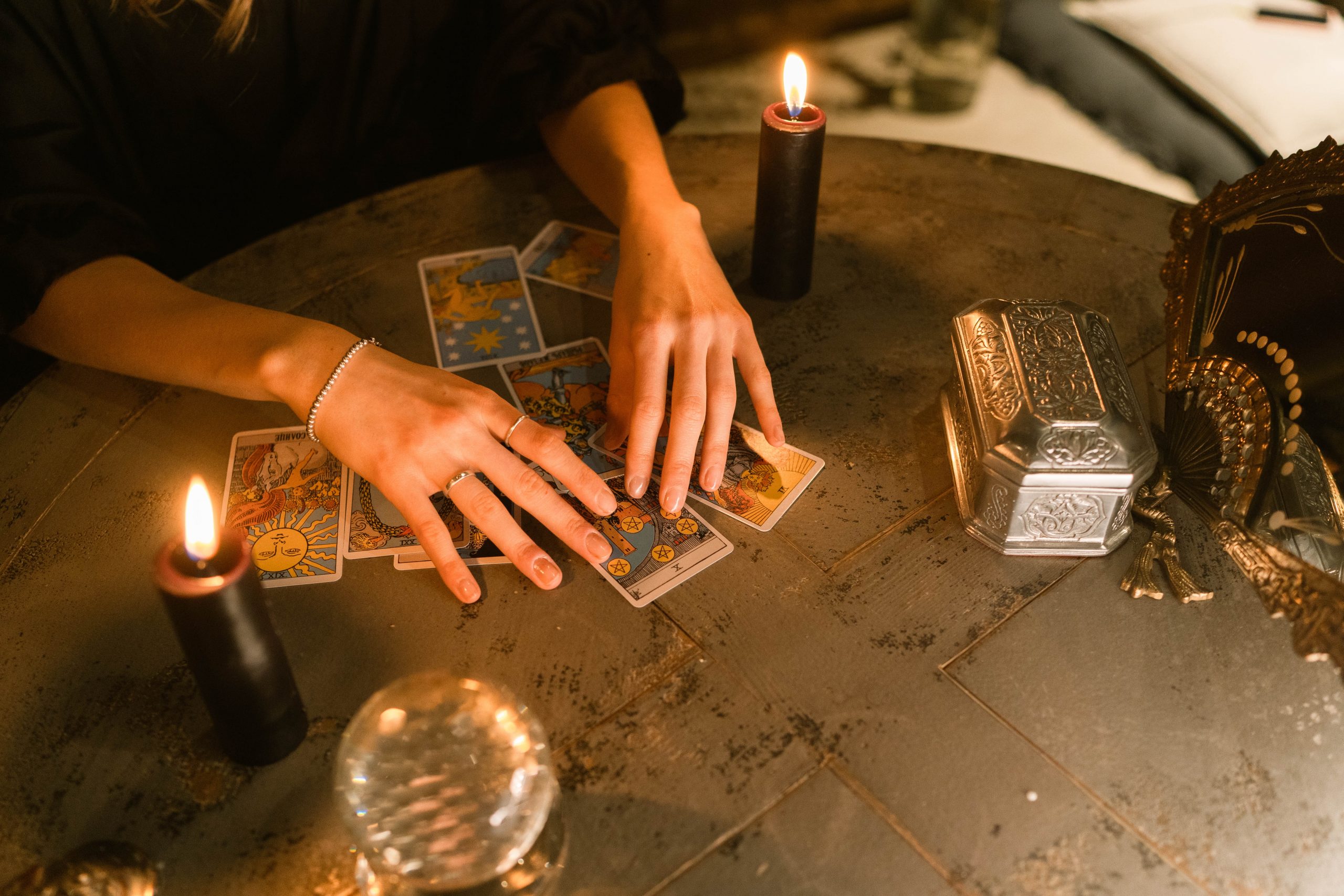 tarot cards black candle crystal ball womans hands reading cards