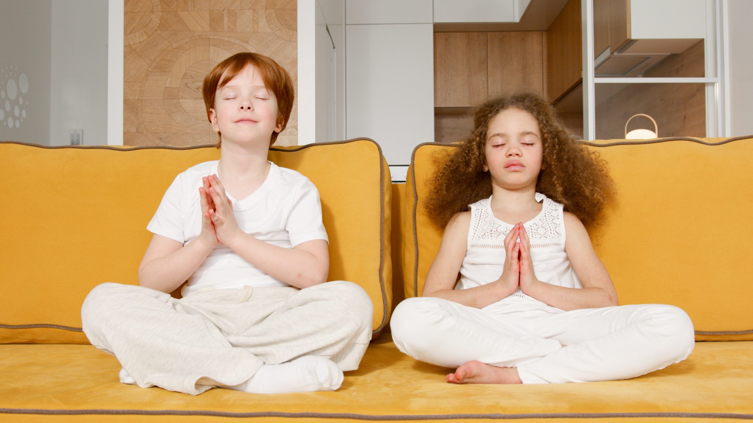 two kids yoga on yellow couch